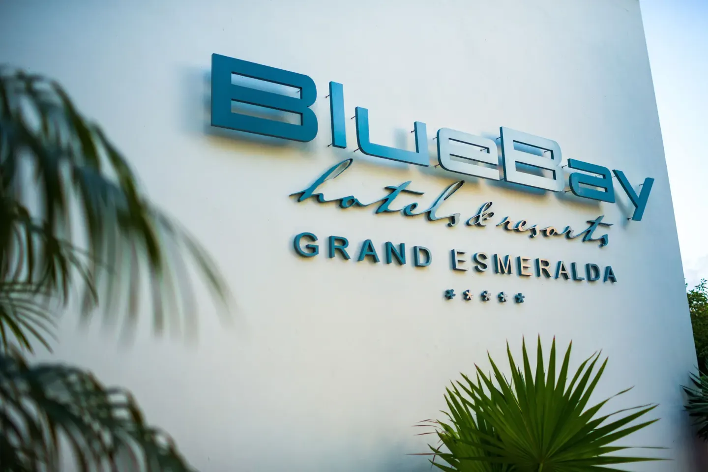 BlueBay Grand Esmeralda wall sign with tropical plants.