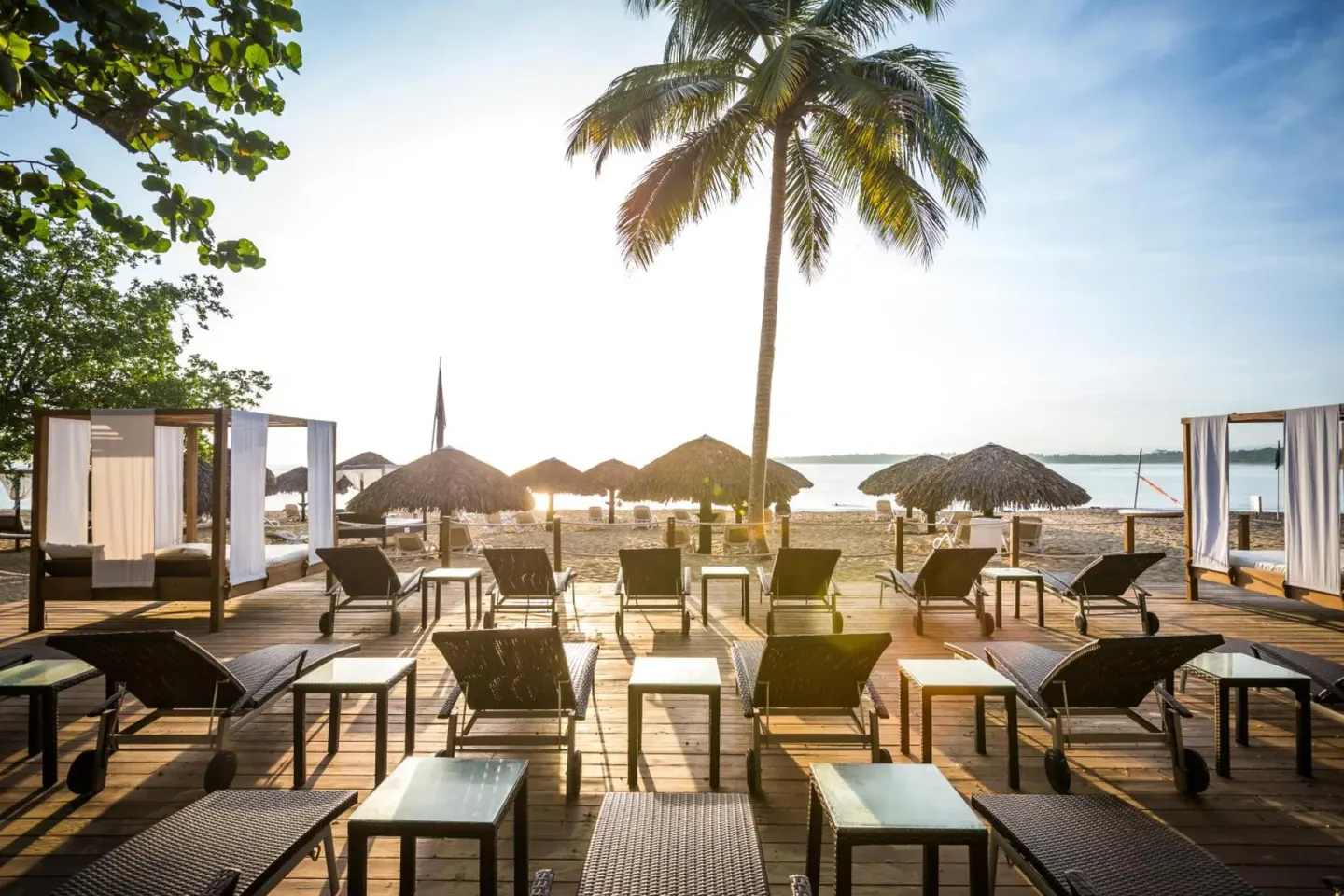 Beach loungers and cabanas face the water at BlueBay Villas Doradas.