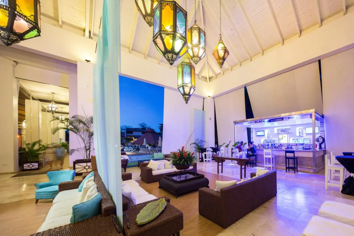 Lobby lounge with hanging lanterns and a bar at BlueBay Villas Doradas.