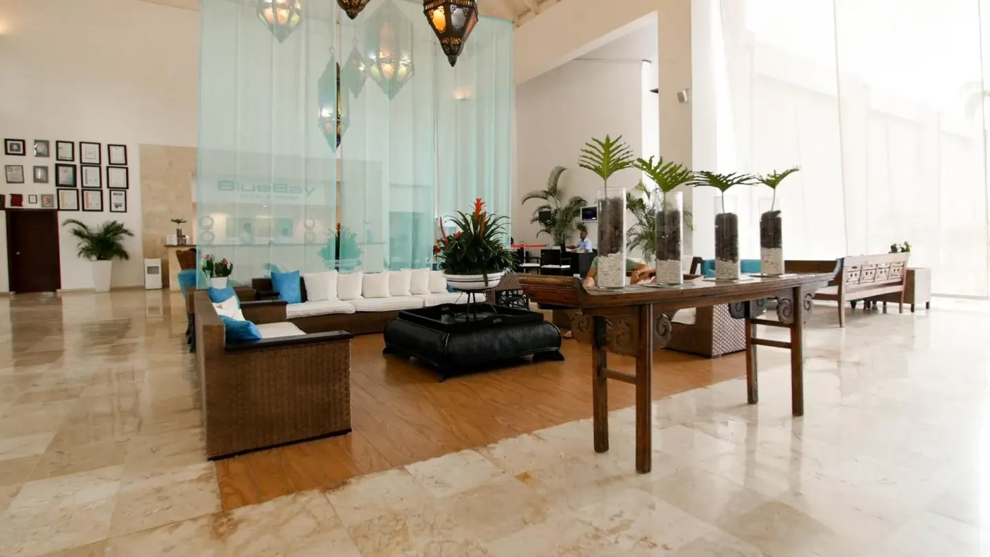 Spacious lobby seating area with wicker sofas at BlueBay Villas Doradas.