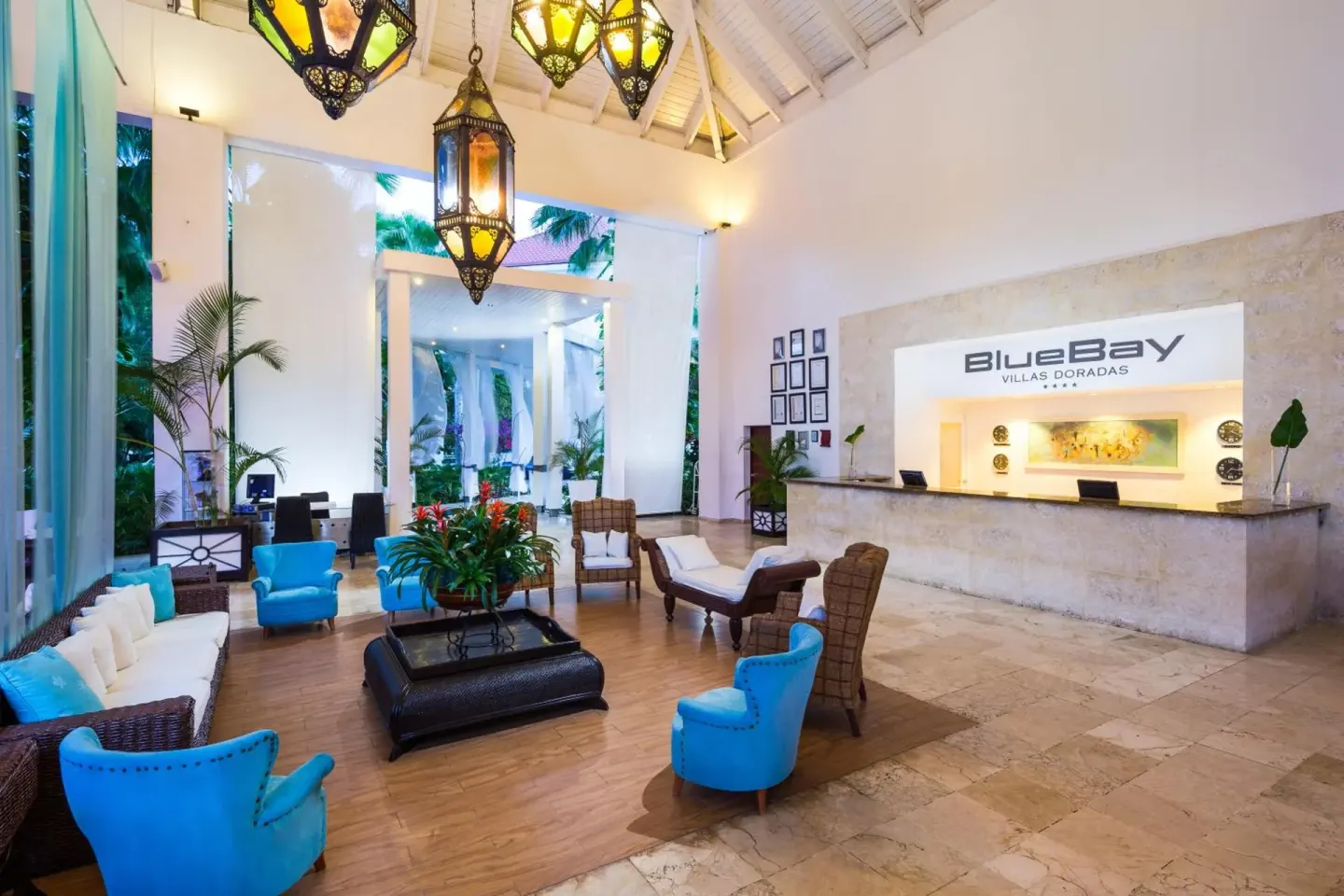 Reception lobby with blue chairs and front desk at BlueBay Villas Doradas.