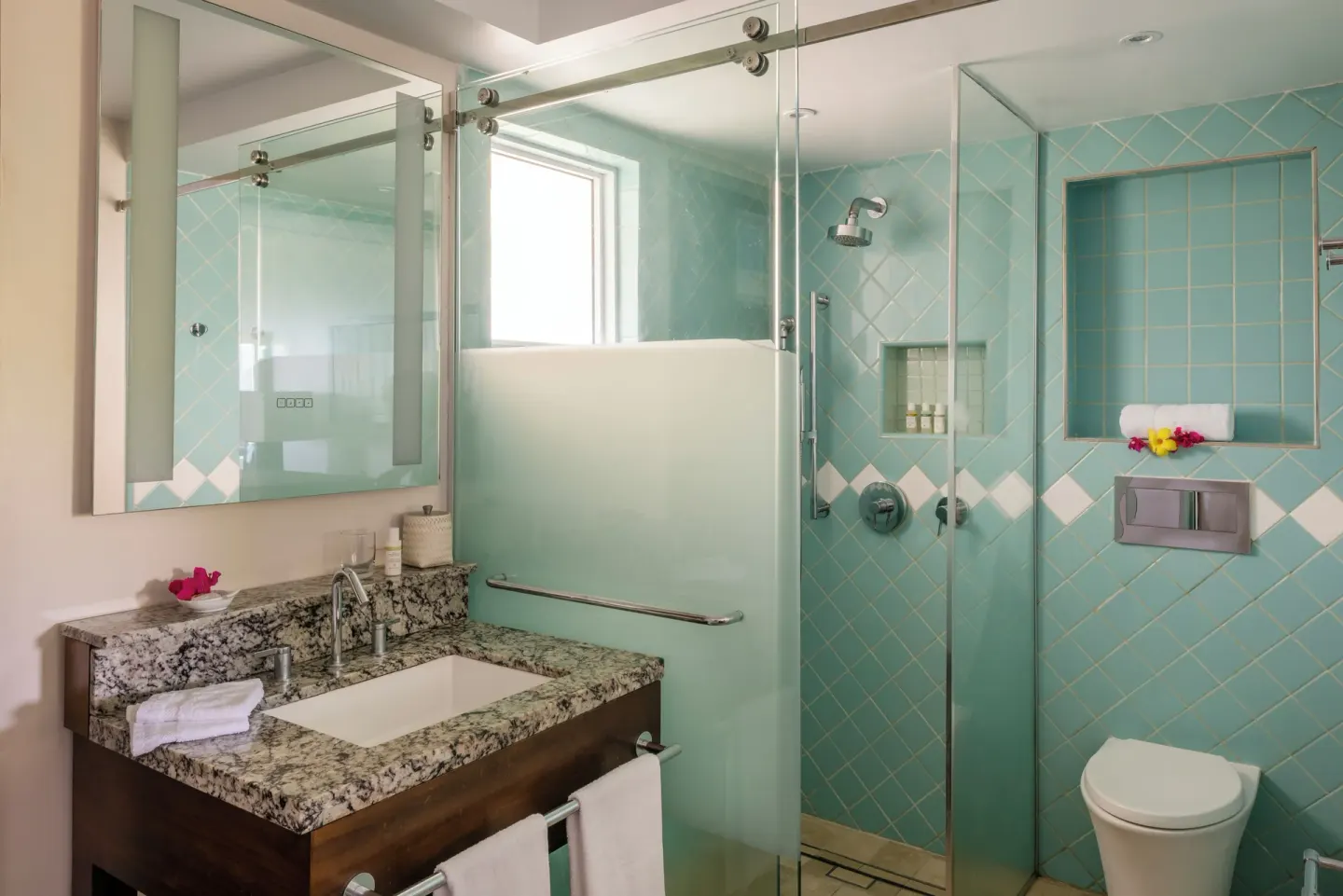 Bathroom vanity, glass shower, and turquoise tile at BodyHoliday.