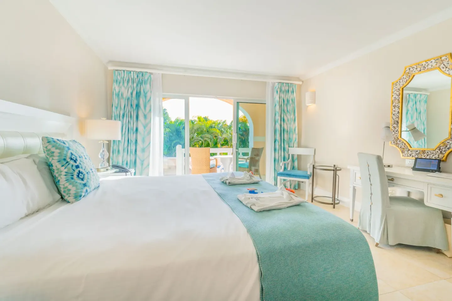 Bright king bed guest room with vanity and balcony doors at BodyHoliday.