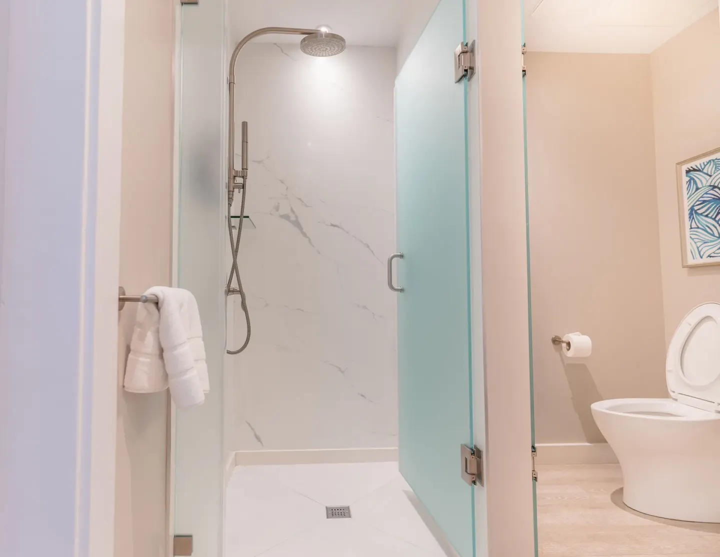 Glass shower and toilet area in a modern bathroom at BodyHoliday.