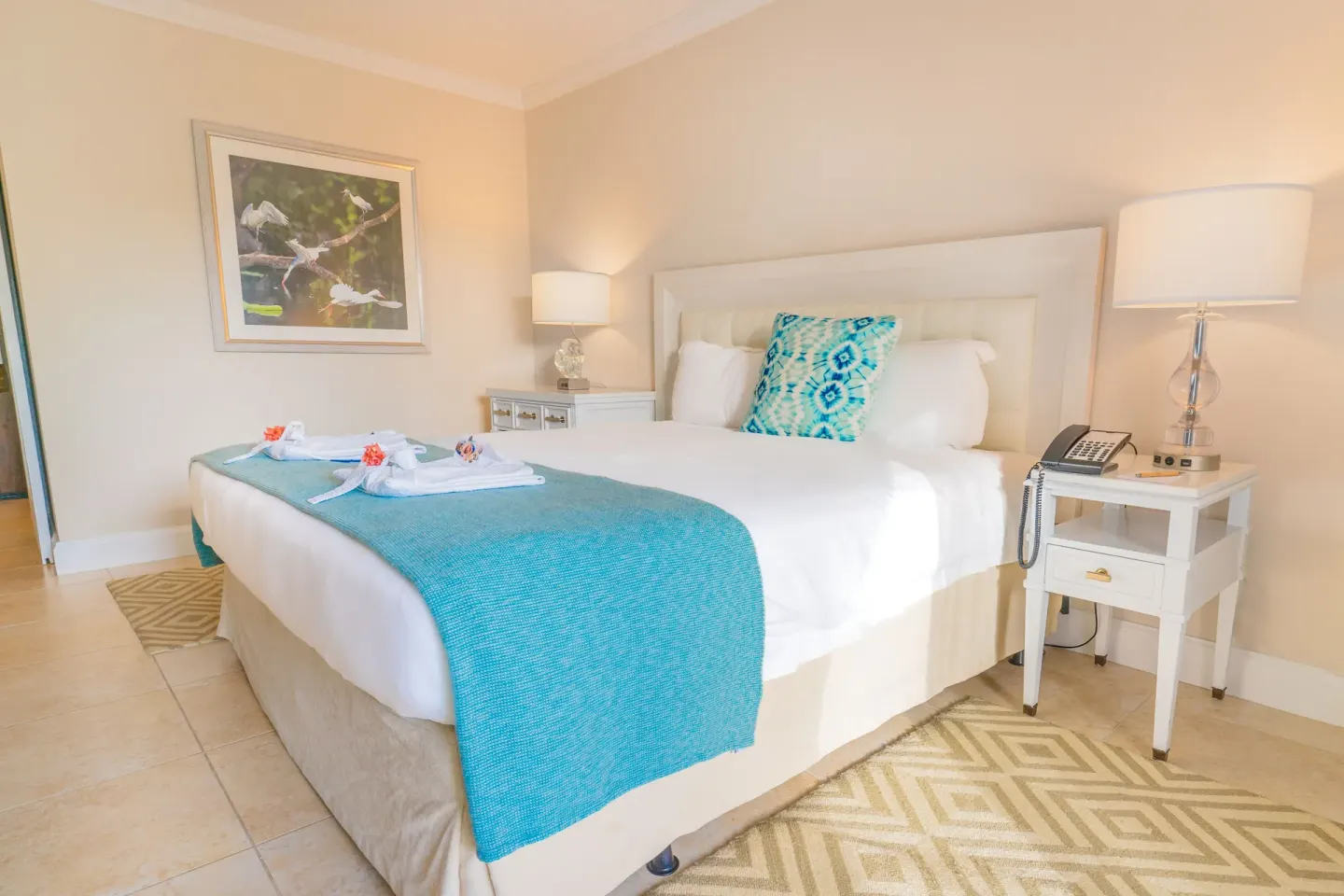 King bed guest room with bedside lamps and bird artwork at BodyHoliday.