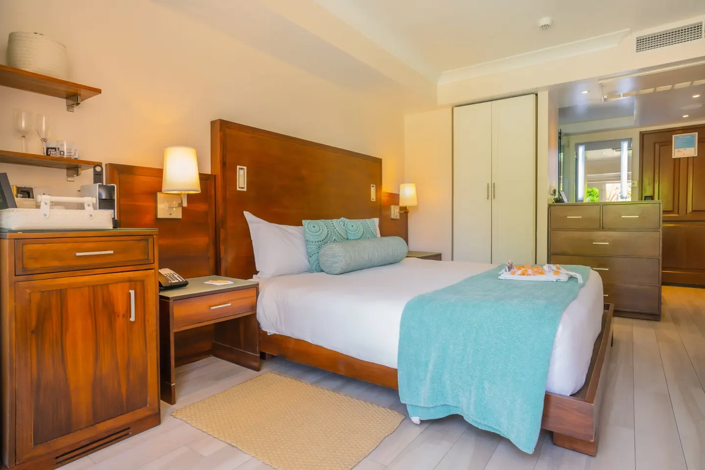 Guest room with wooden headboard, king bed, storage, and vanity area at BodyHoliday.