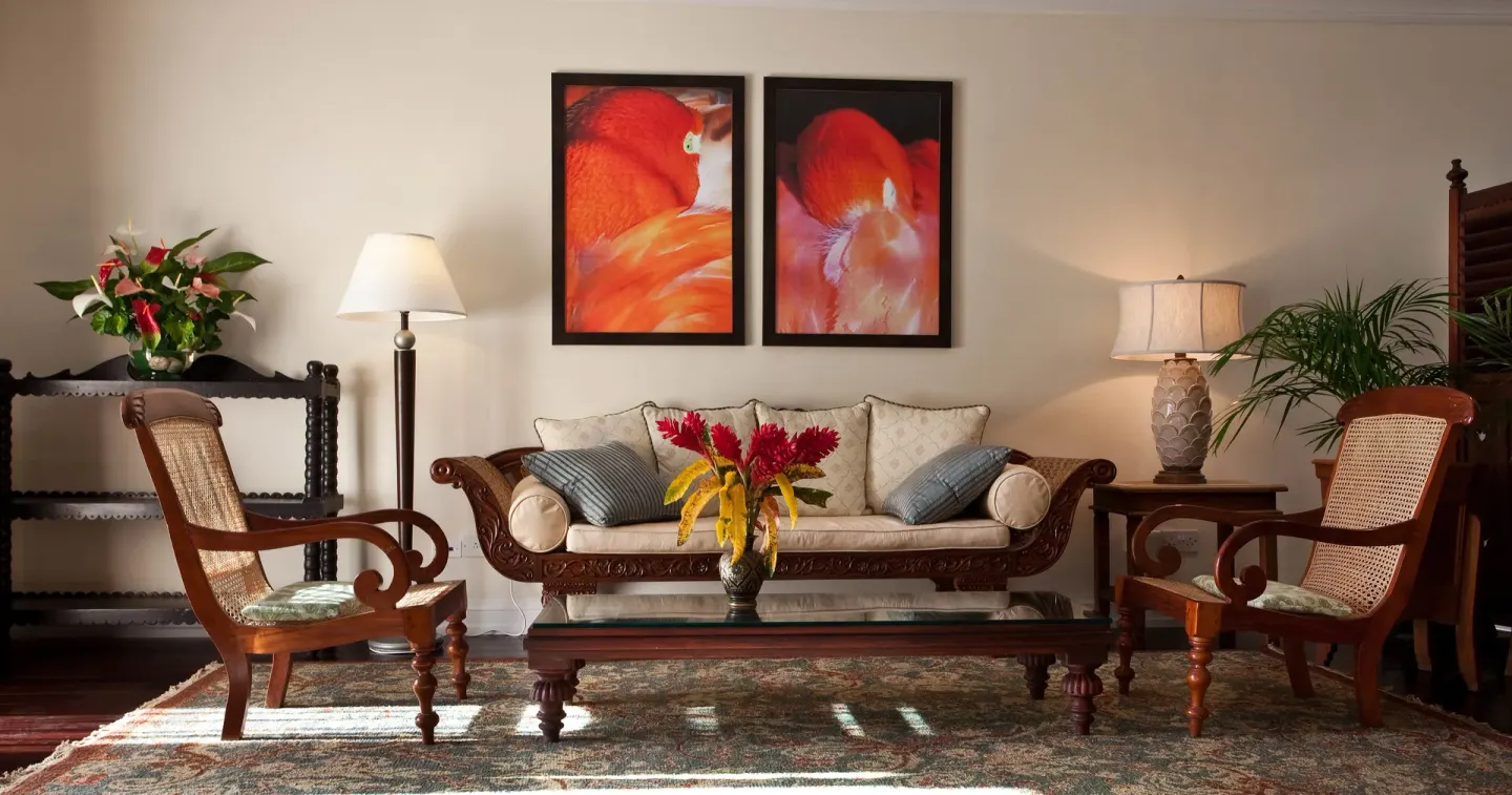 Lounge seating at BodyHoliday with carved chairs, sofa, floral arrangements and bird artwork.