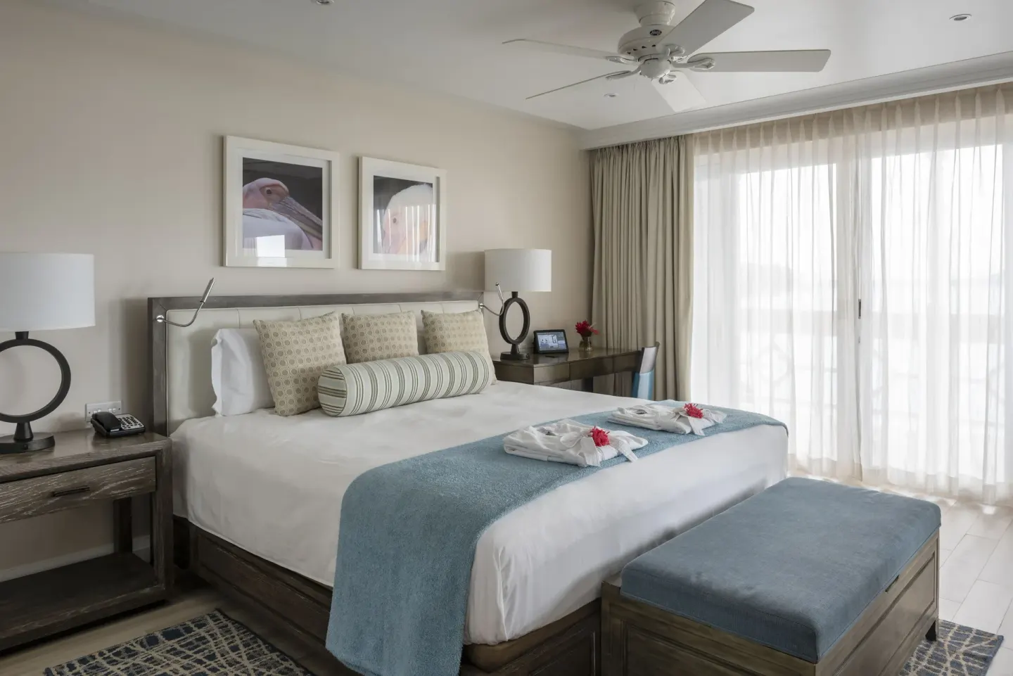 Modern king bed guest room with bench, desk, and sheer curtains at BodyHoliday.