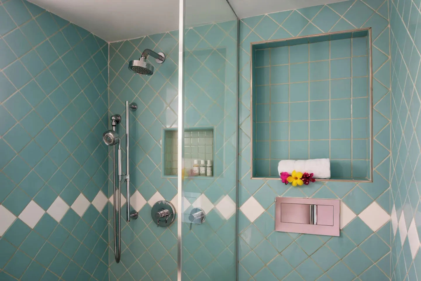 Turquoise tiled shower with towel and flowers at BodyHoliday.