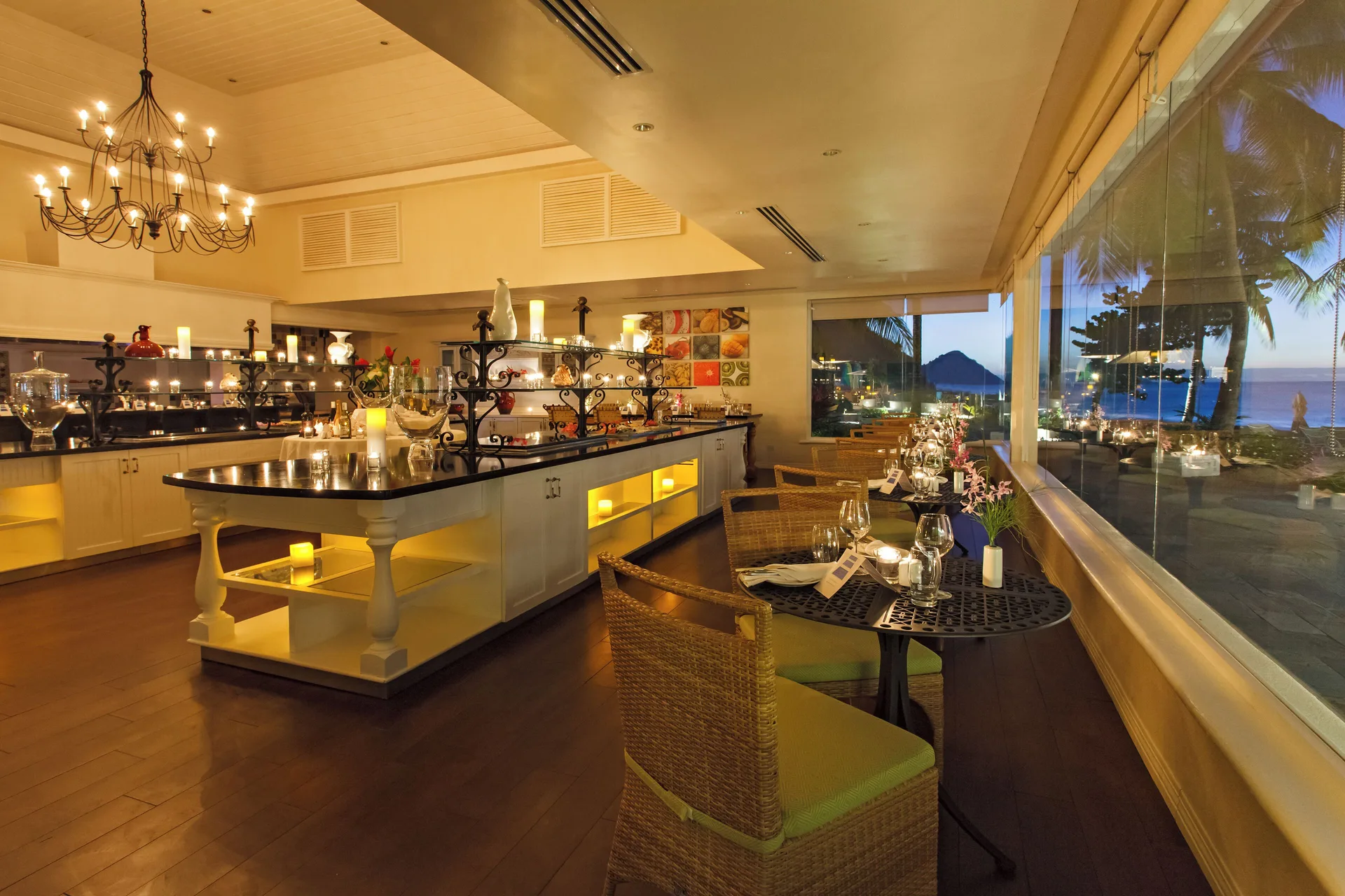 A candlelit dining room overlooks the sea at BodyHoliday.