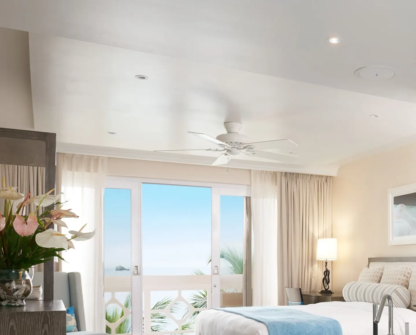 Grand Room Oceanfront bed beside balcony doors with ocean beyond at BodyHoliday.