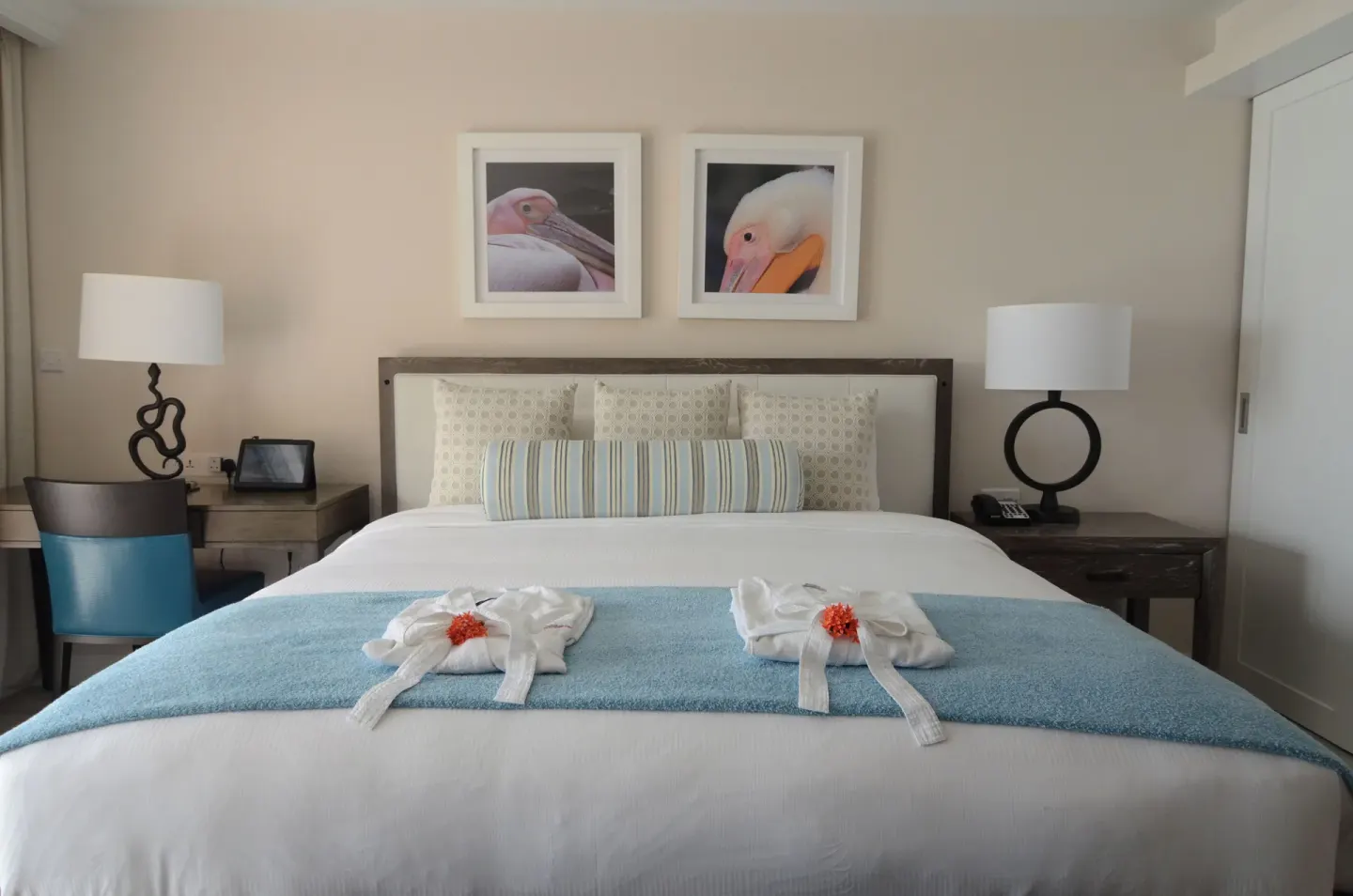 Grand Room Oceanfront king bed with bedside lamps and bird artwork at BodyHoliday.