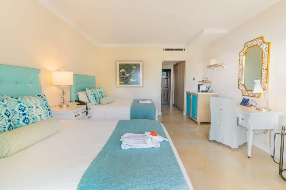 Garden View room at BodyHoliday with twin beds, turquoise headboards, and vanity desk.