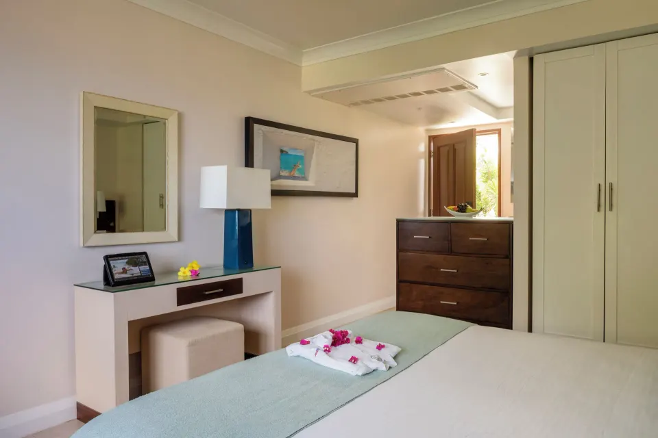 Oceanfront room dresser, vanity, and bed corner at BodyHoliday.