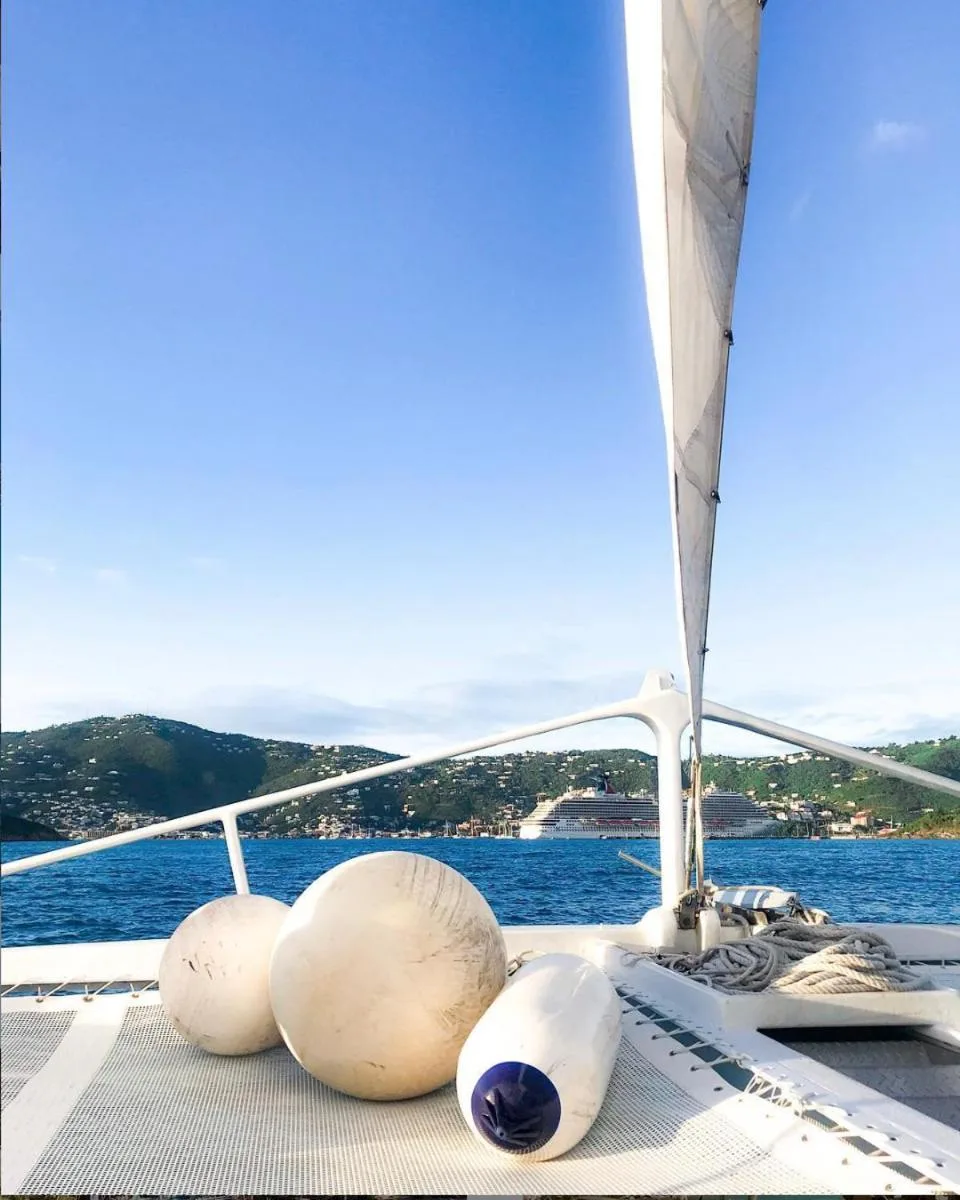 Catamaran deck with sail, ropes, and fenders on the water near Bolongo Bay Beach Resort.