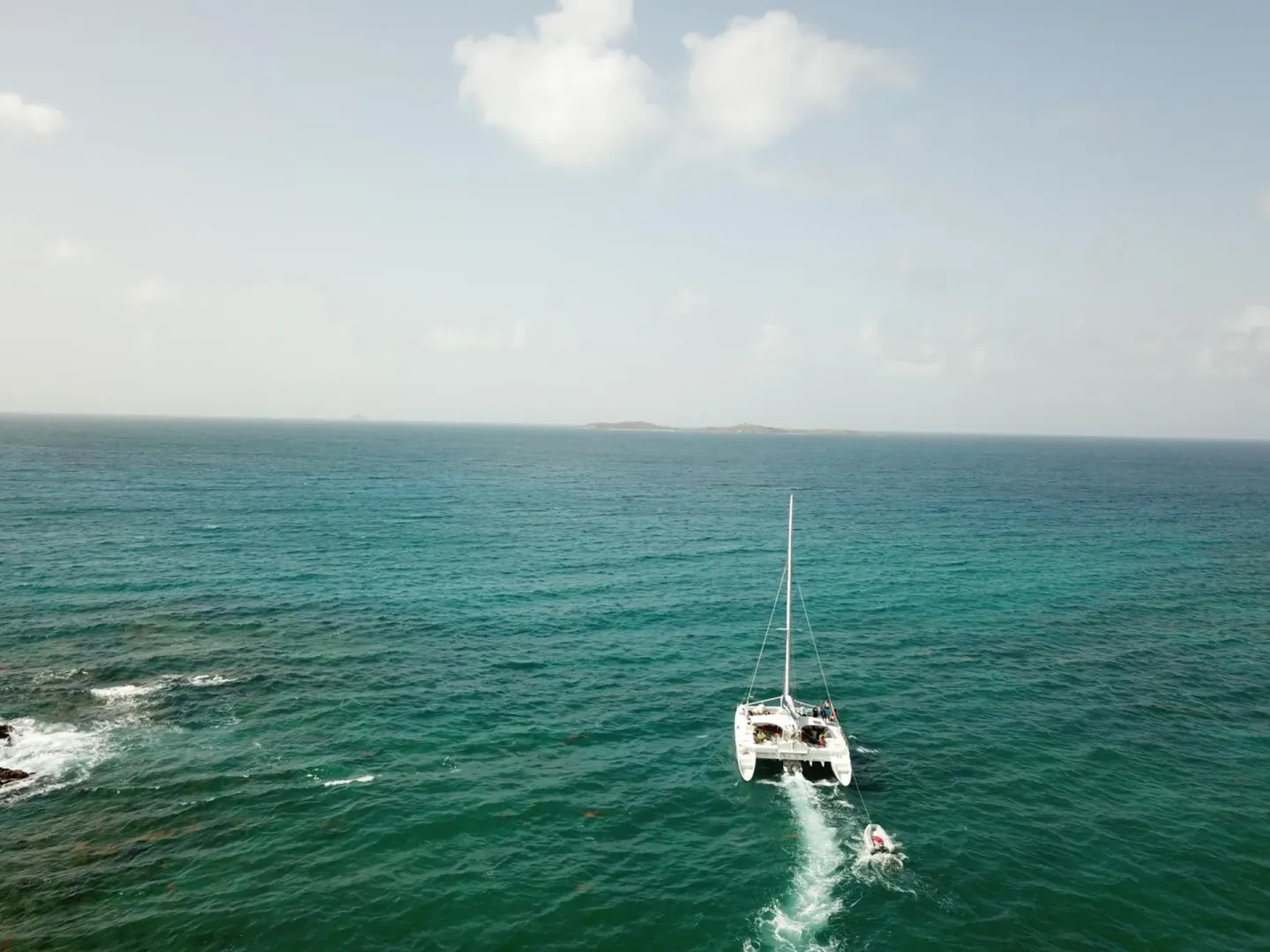 A catamaran sails across open turquoise water near Bolongo Bay Beach Resort.