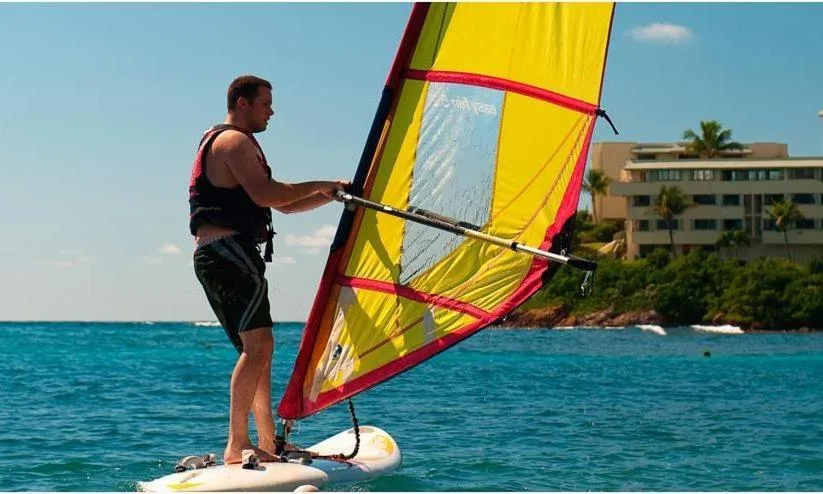 A guest windsurfs on blue water near Bolongo Bay Beach Resort.