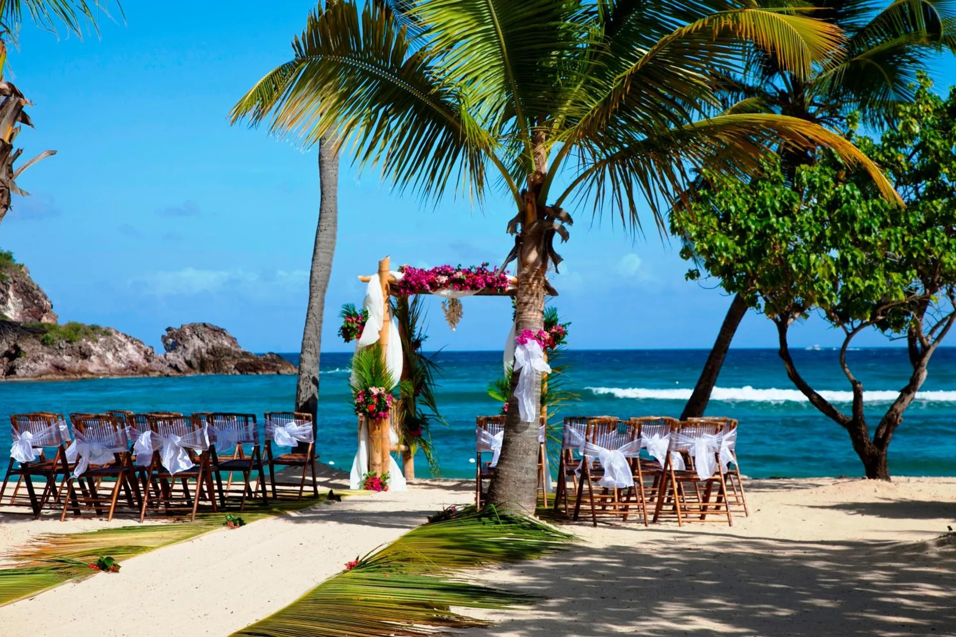Beach wedding ceremony setup with floral arch at Bolongo Bay Beach Resort.
