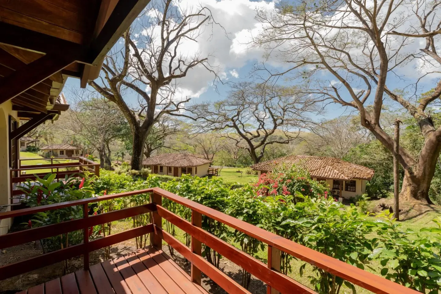 Balcony overlooking tiled-roof cottages and trees at Borinquen Thermal Resort.