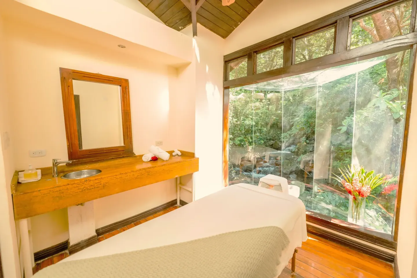 Massage room with garden-facing glass wall at Borinquen Thermal Resort.