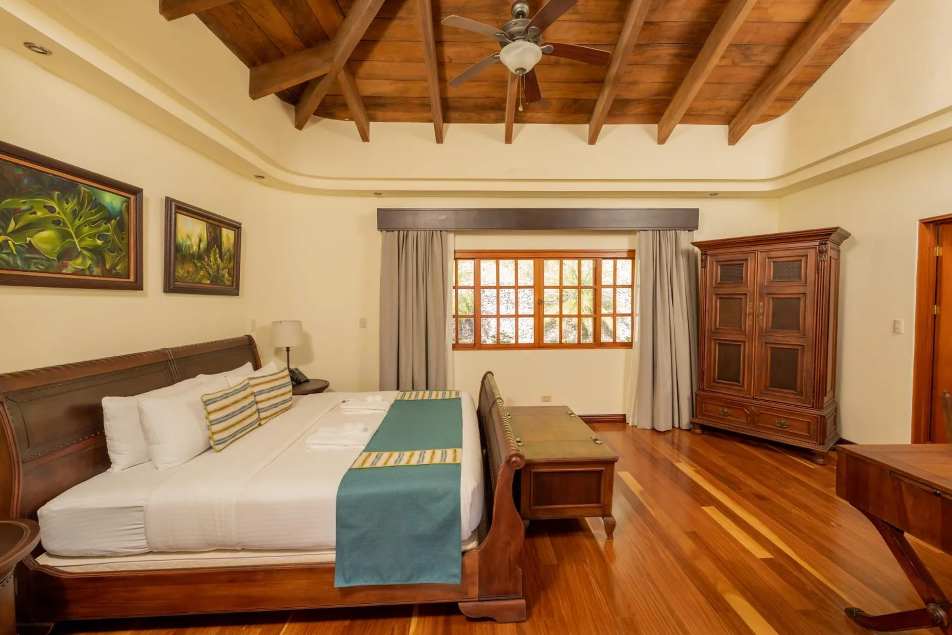 Guest room with king bed and wood ceiling at Borinquen Thermal Resort.