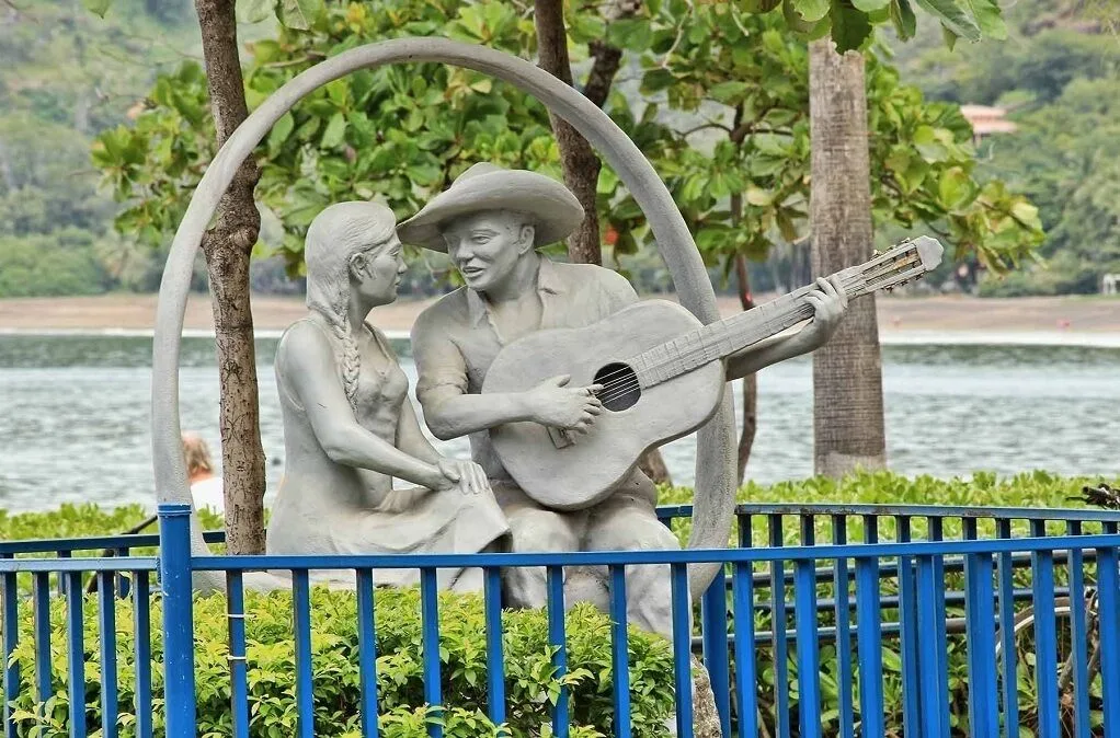 Lakeside sculpture of a guitarist and seated woman at Borinquen Thermal Resort.