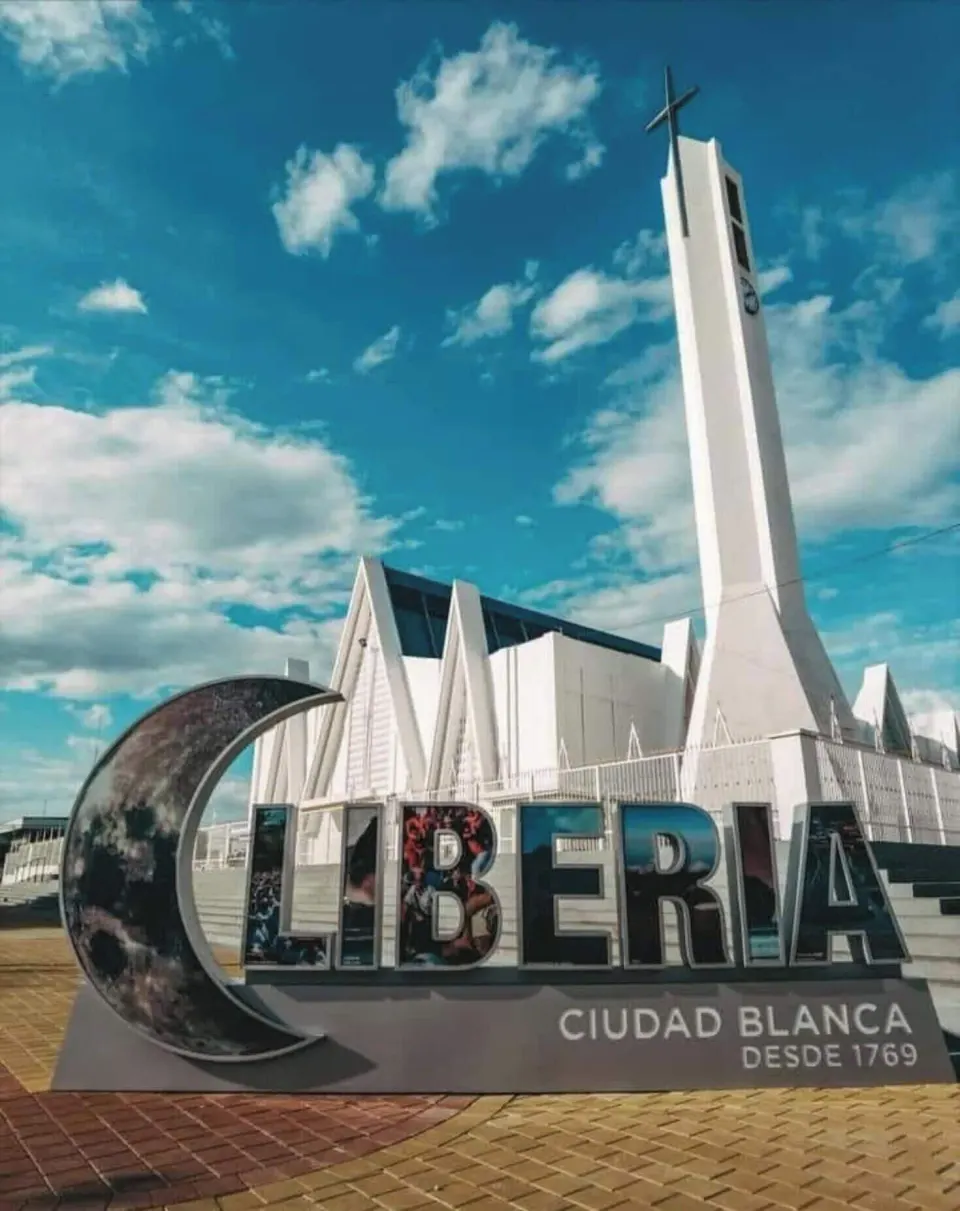 Liberia city sign and white church tower near Borinquen Thermal Resort.