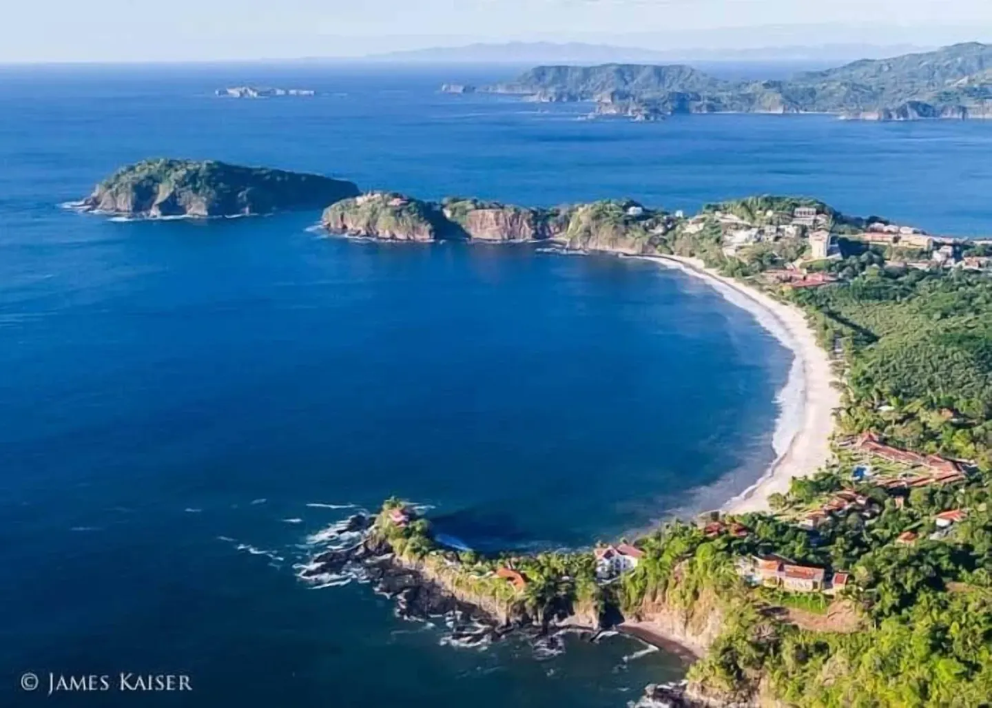 Aerial view of a Pacific bay and coastline near Borinquen Thermal Resort.