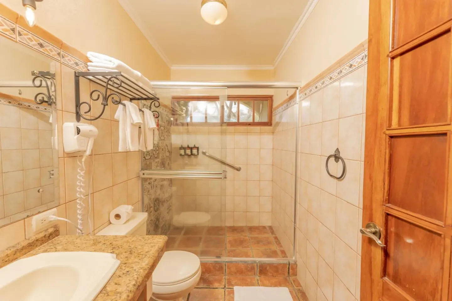 Tiled bathroom with walk-in shower and vanity at Borinquen Thermal Resort.