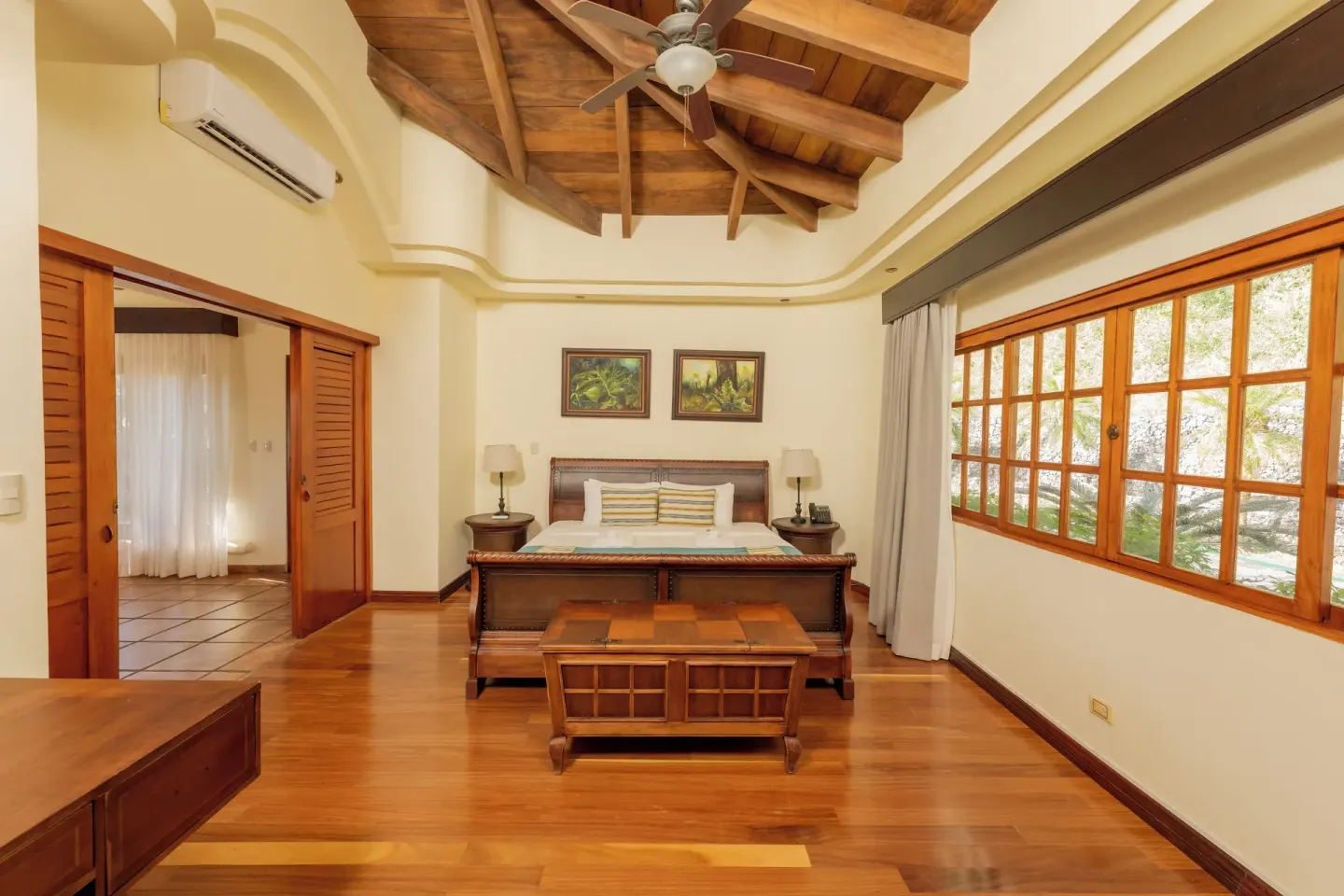 Junior Suite bedroom with wood ceiling and large windows at Borinquen Thermal Resort.