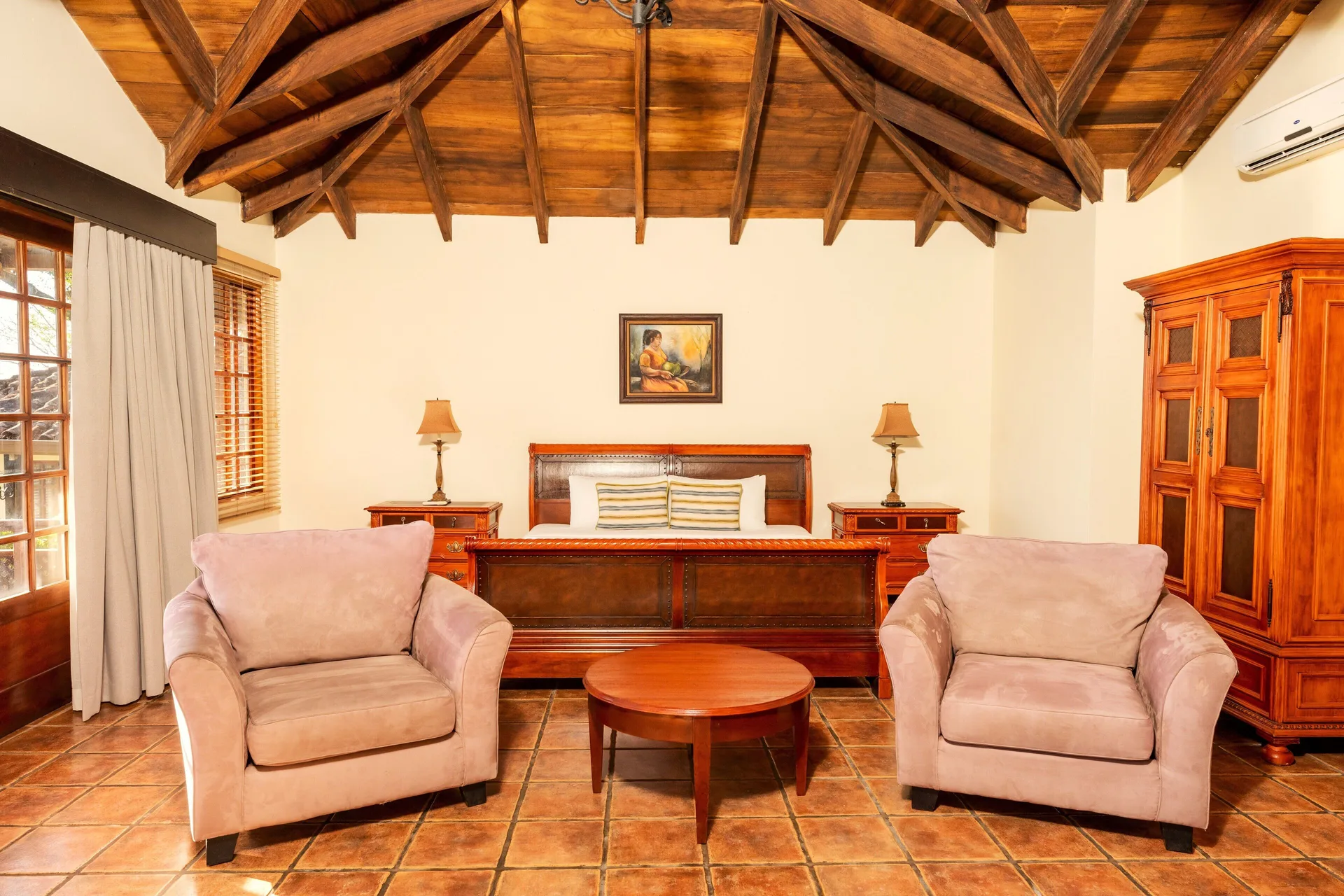 Superior Bungalow guest room with king bed and armchairs at Borinquen Thermal Resort.
