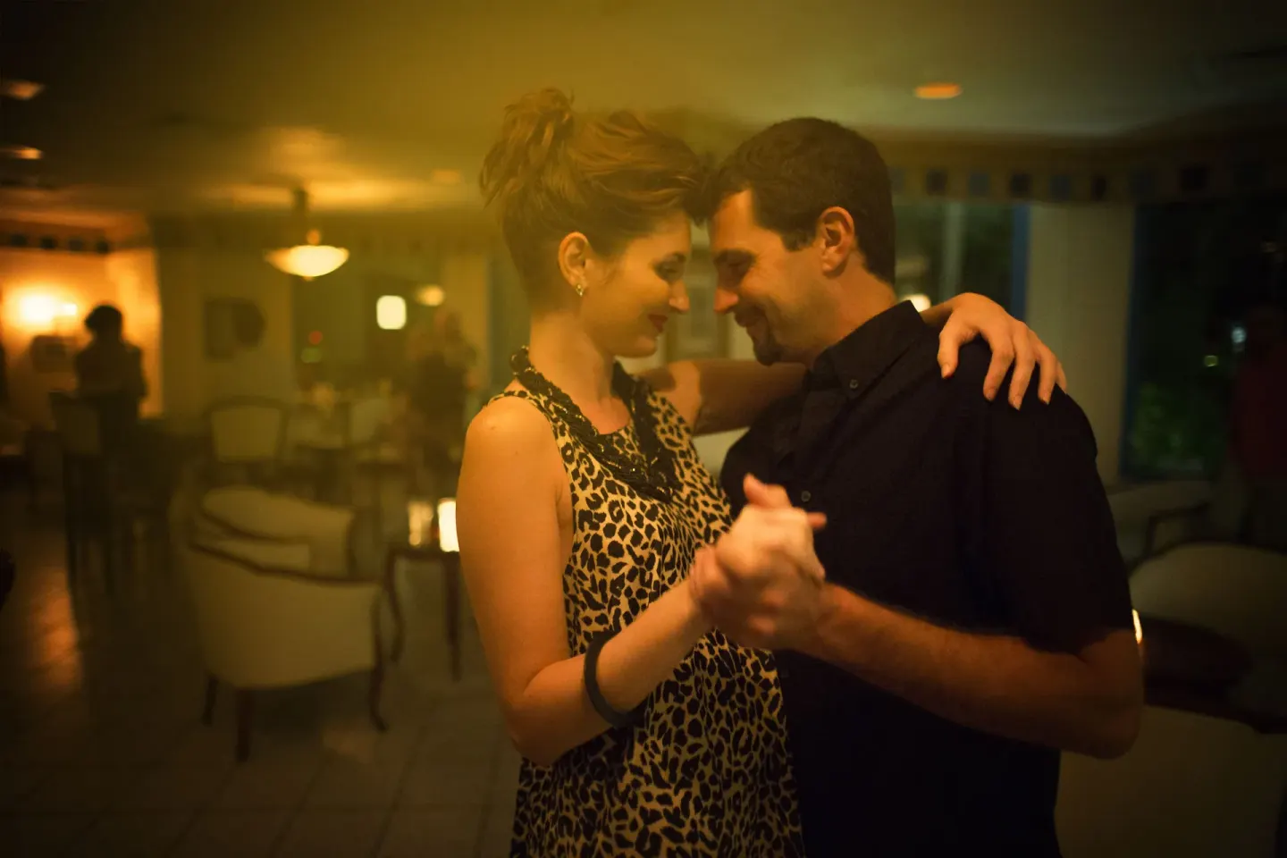 Couple dancing in a softly lit lounge at Breezes Resort Bahamas.