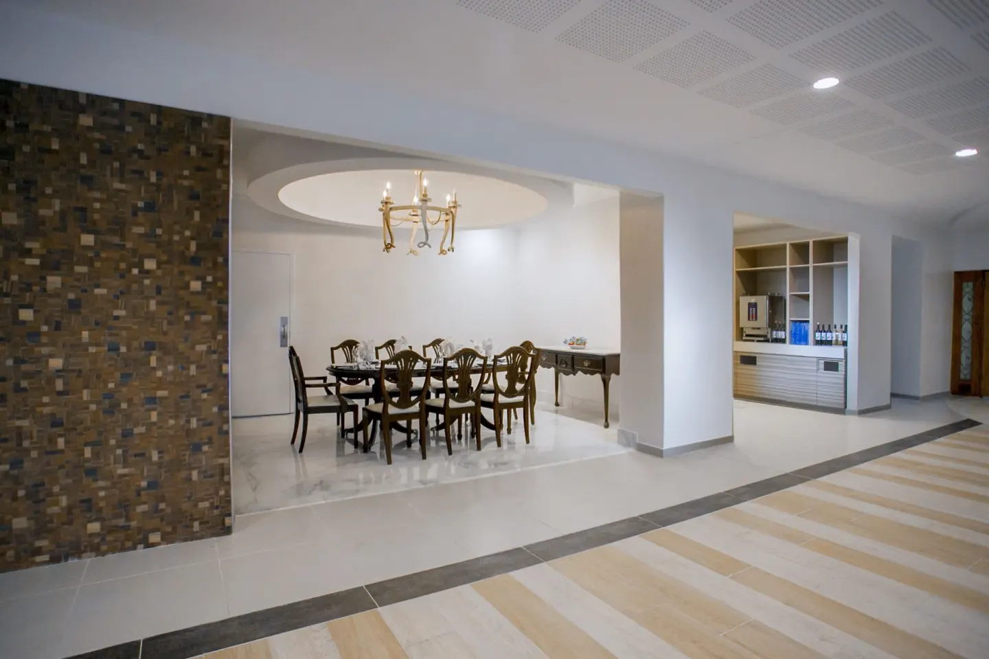 Lobby-adjacent seating area with chandelier and refreshment station at Breezes Resort Bahamas.