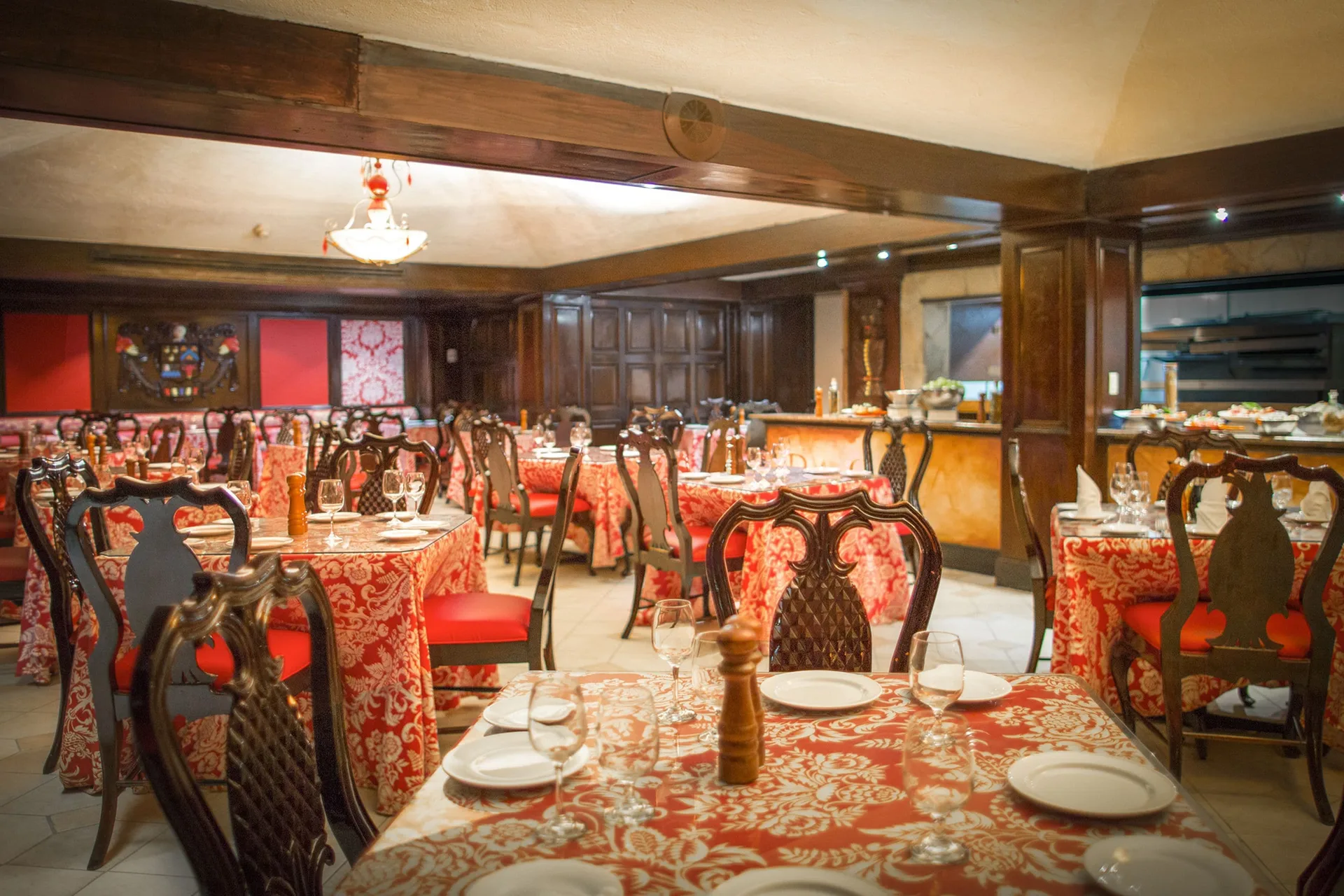 Dining room with red patterned tablecloths and carved chairs at Breezes Resort Bahamas.