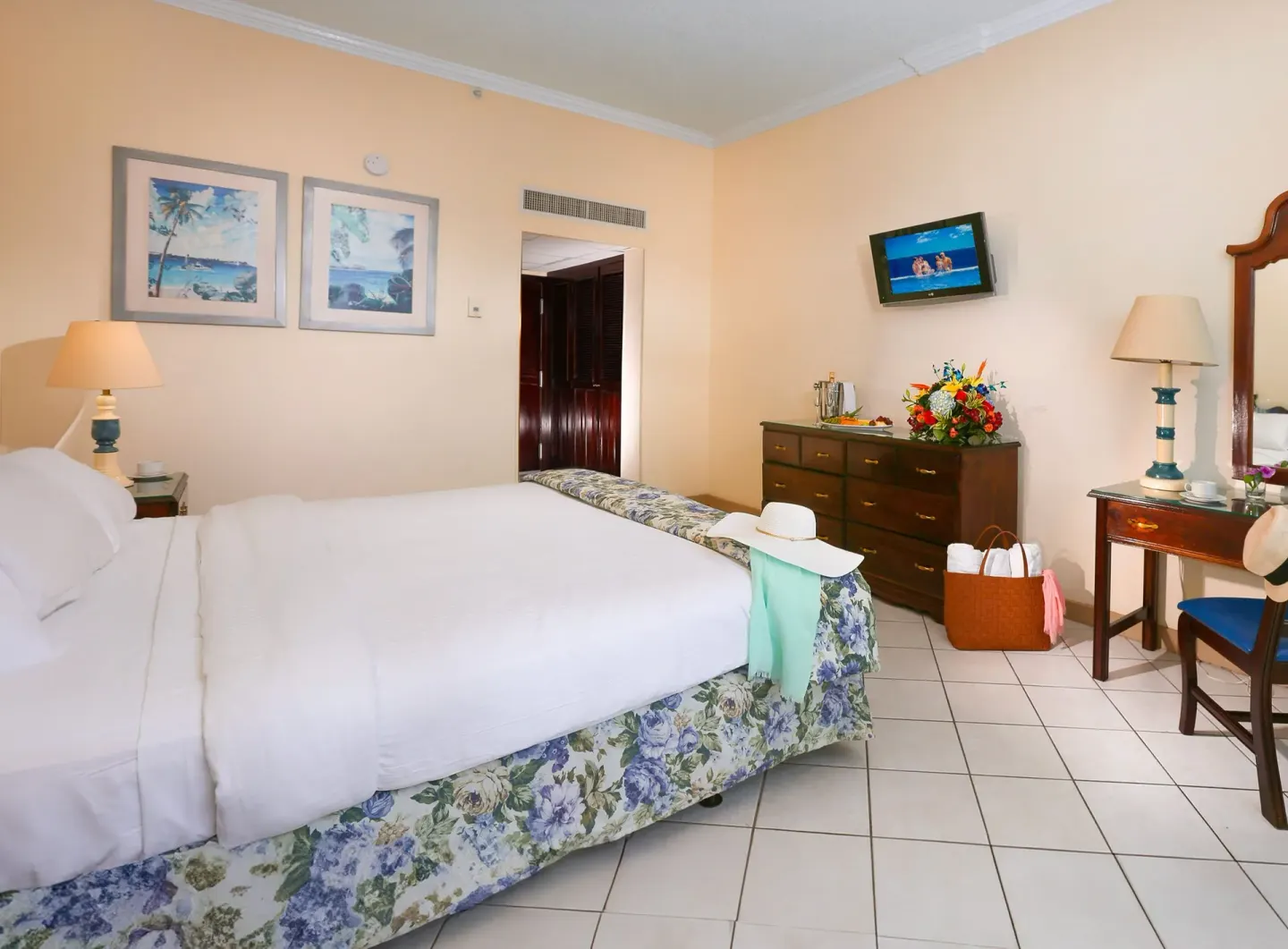 Classic Room with king bed, dresser, beach prints, and desk at Breezes Resort Bahamas.