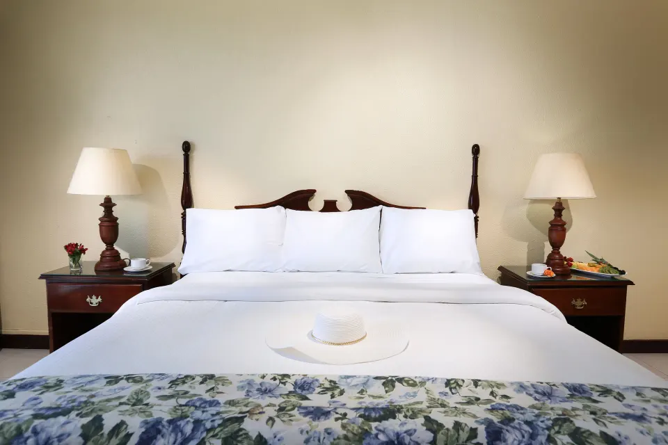 Classic Room king bed with bedside tables and lamps at Breezes Resort Bahamas.