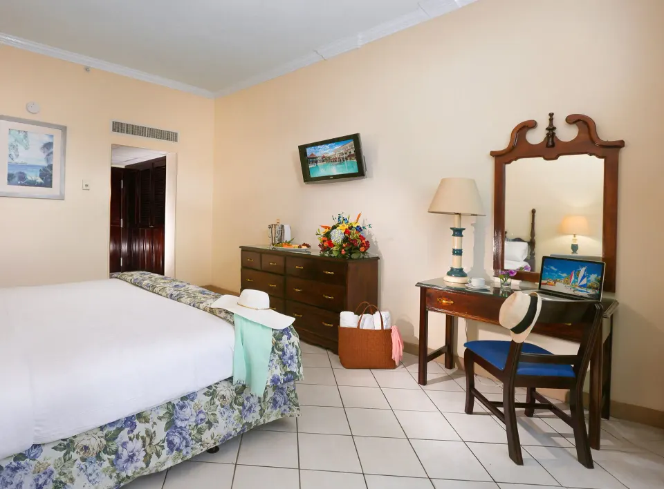 Classic Room with king bed, dresser, desk, and mirror at Breezes Resort Bahamas.