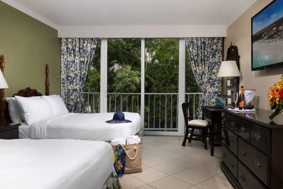 Classic Room with two beds, floral curtains, and a dresser at Breezes Resort Bahamas.