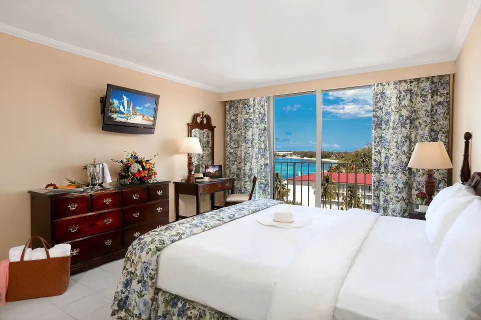 Partial Ocean View Room with king bed and distant ocean view at Breezes Resort Bahamas.