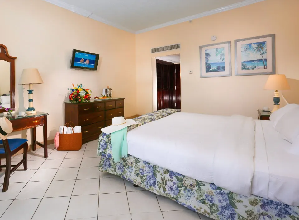 Partial Ocean View Room with king bed, dresser, vanity, and TV at Breezes Resort Bahamas.