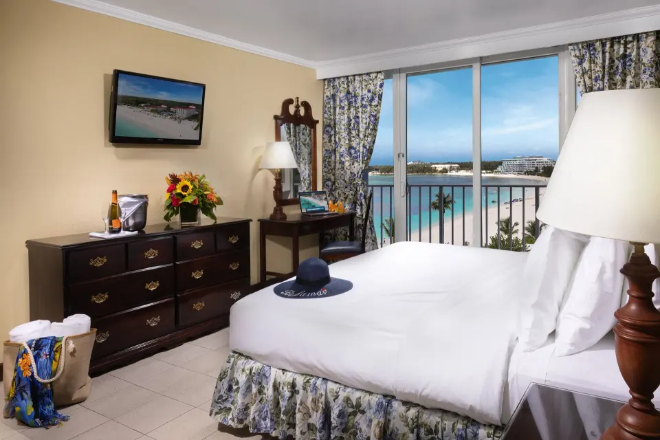 Partial Ocean View Room with king bed, dresser, and balcony view at Breezes Resort Bahamas.