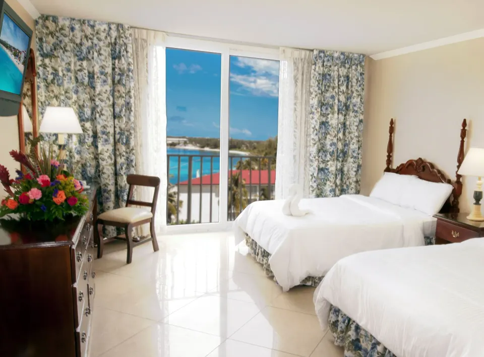 Partial Ocean View Room with two beds and balcony doors at Breezes Resort Bahamas.