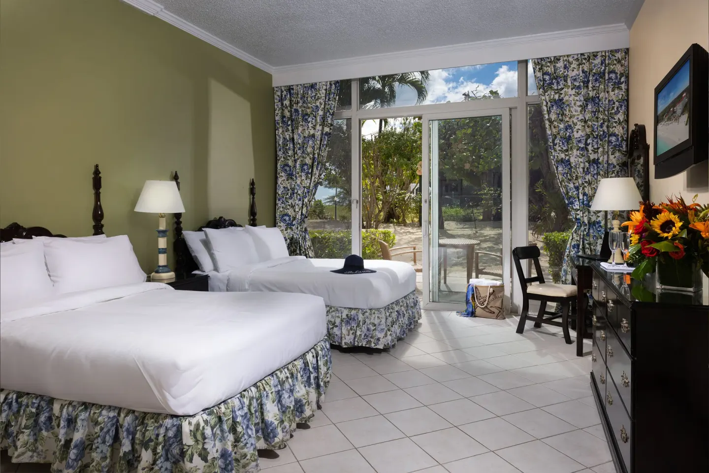 Patio Room Garden View with two beds and sliding doors at Breezes Resort Bahamas.