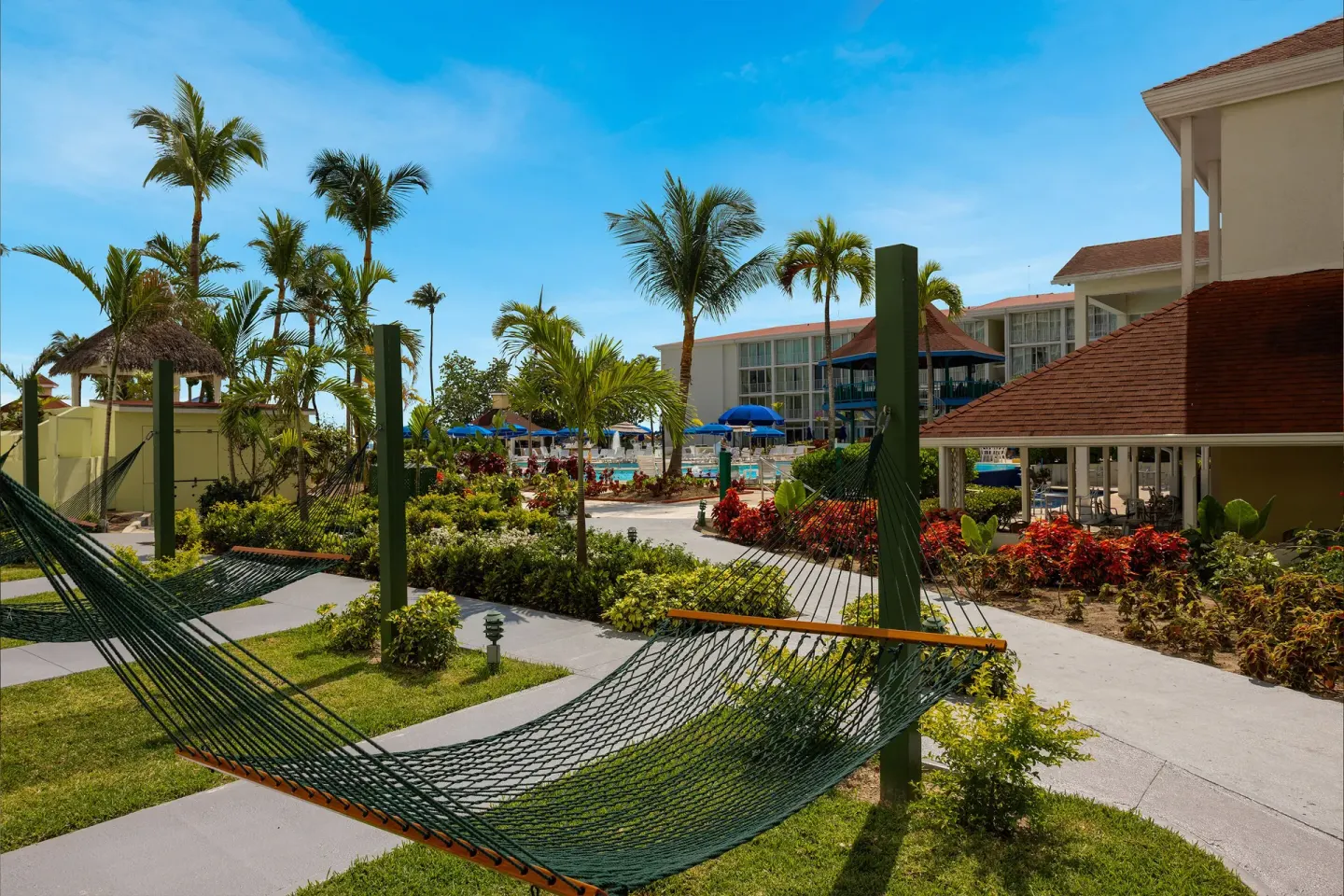 Pool-view patio area with hammocks, palms, and resort buildings at Breezes Resort Bahamas.