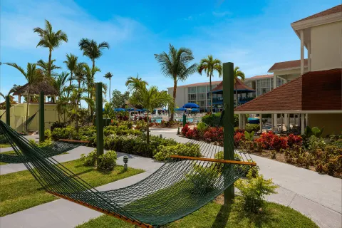 Pool-view patio area with hammocks, palms, and resort buildings at Breezes Resort Bahamas.
