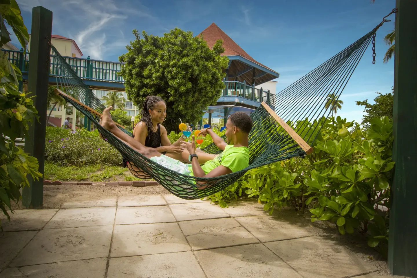 Patio hammock outside a Pool View room at Breezes Resort Bahamas with guests and drinks.