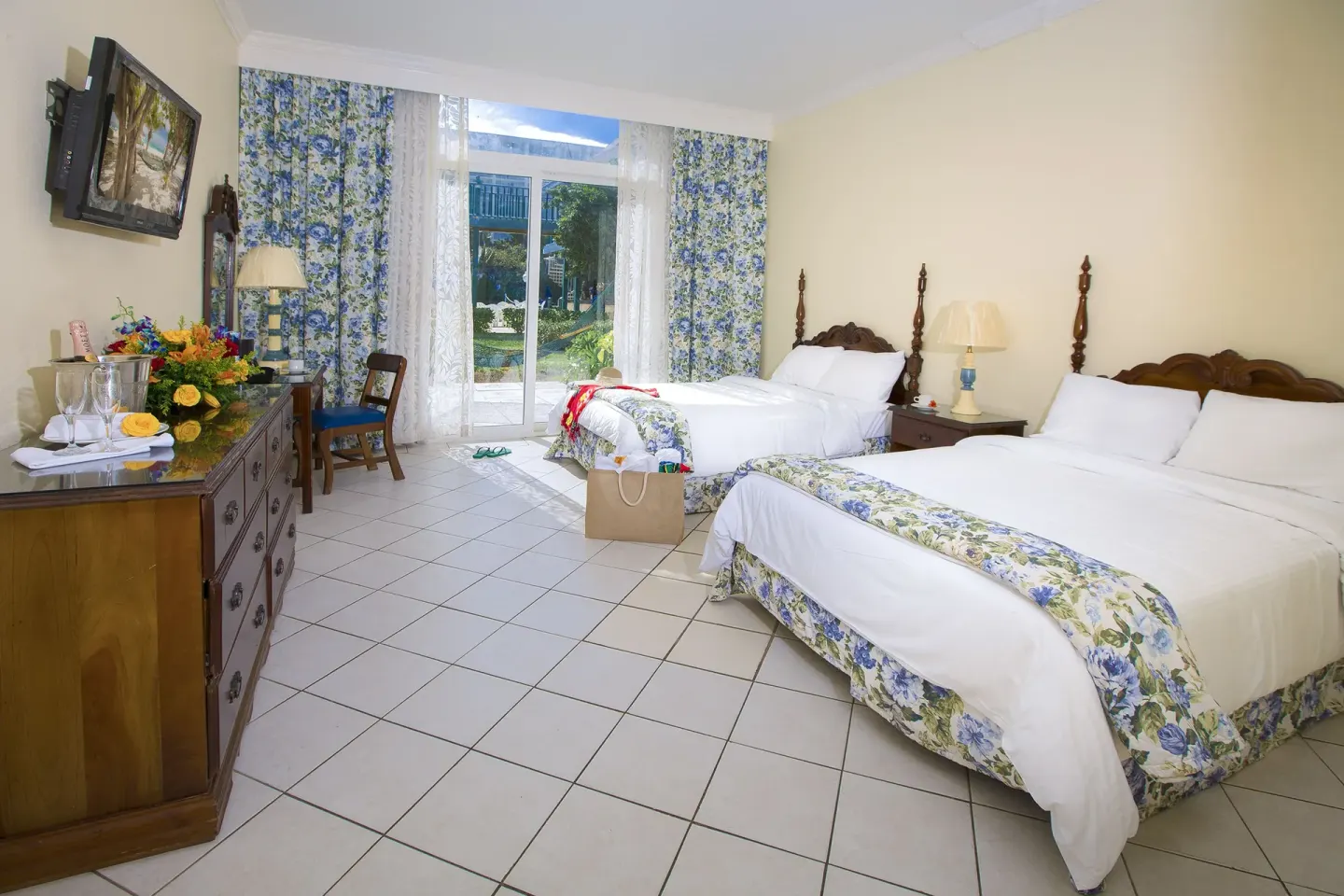 Patio Room with two beds and garden-facing glass doors at Breezes Resort Bahamas.