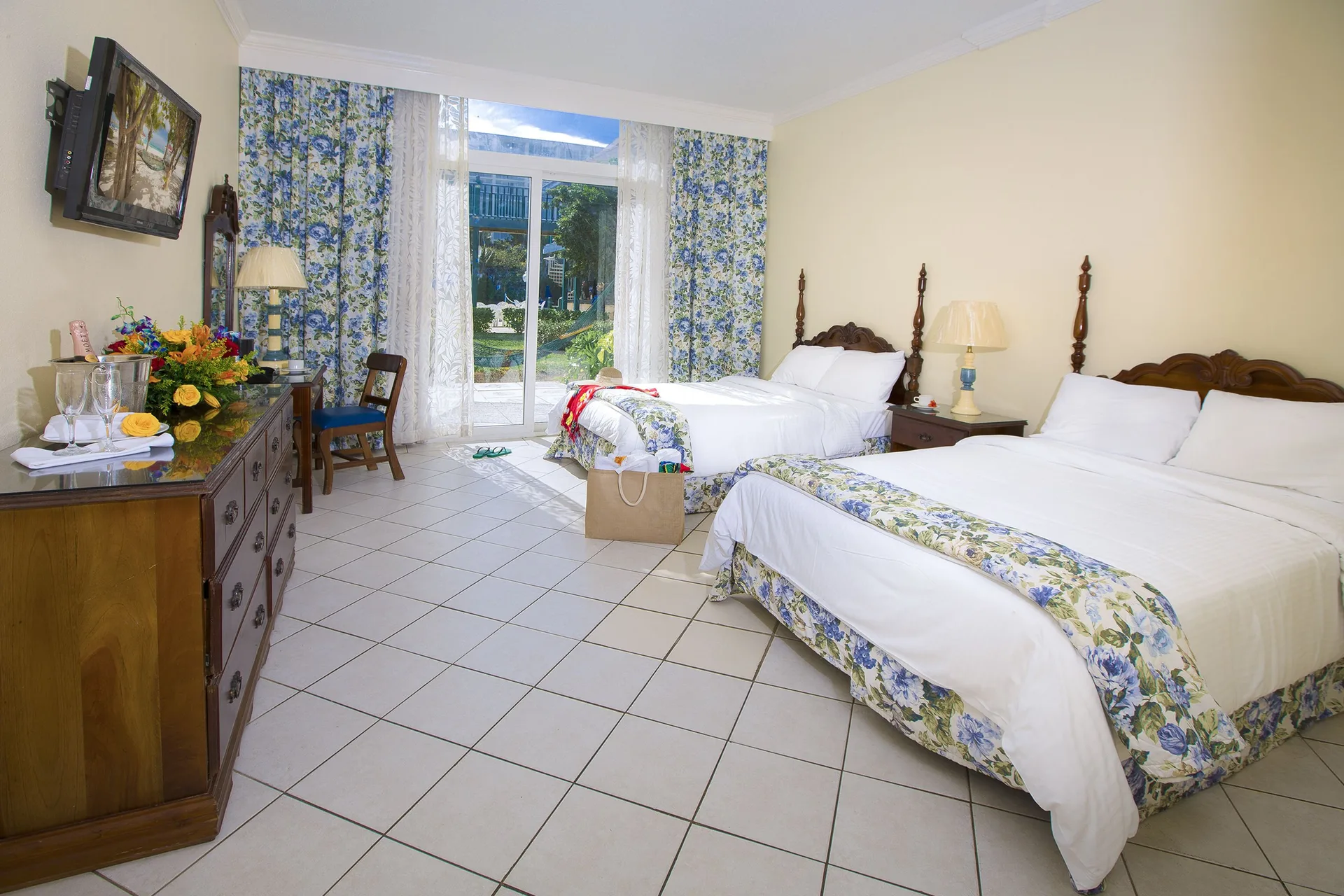 Patio Room with two beds and garden-facing glass doors at Breezes Resort Bahamas.