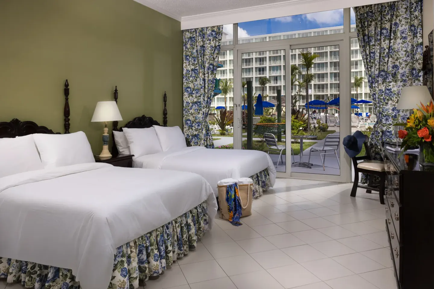 Patio Room with two beds and pool-facing glass doors at Breezes Resort Bahamas.