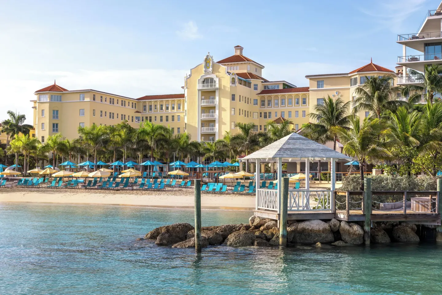 Beachfront hotel façade, loungers, umbrellas, and gazebo at British Colonial Nassau.